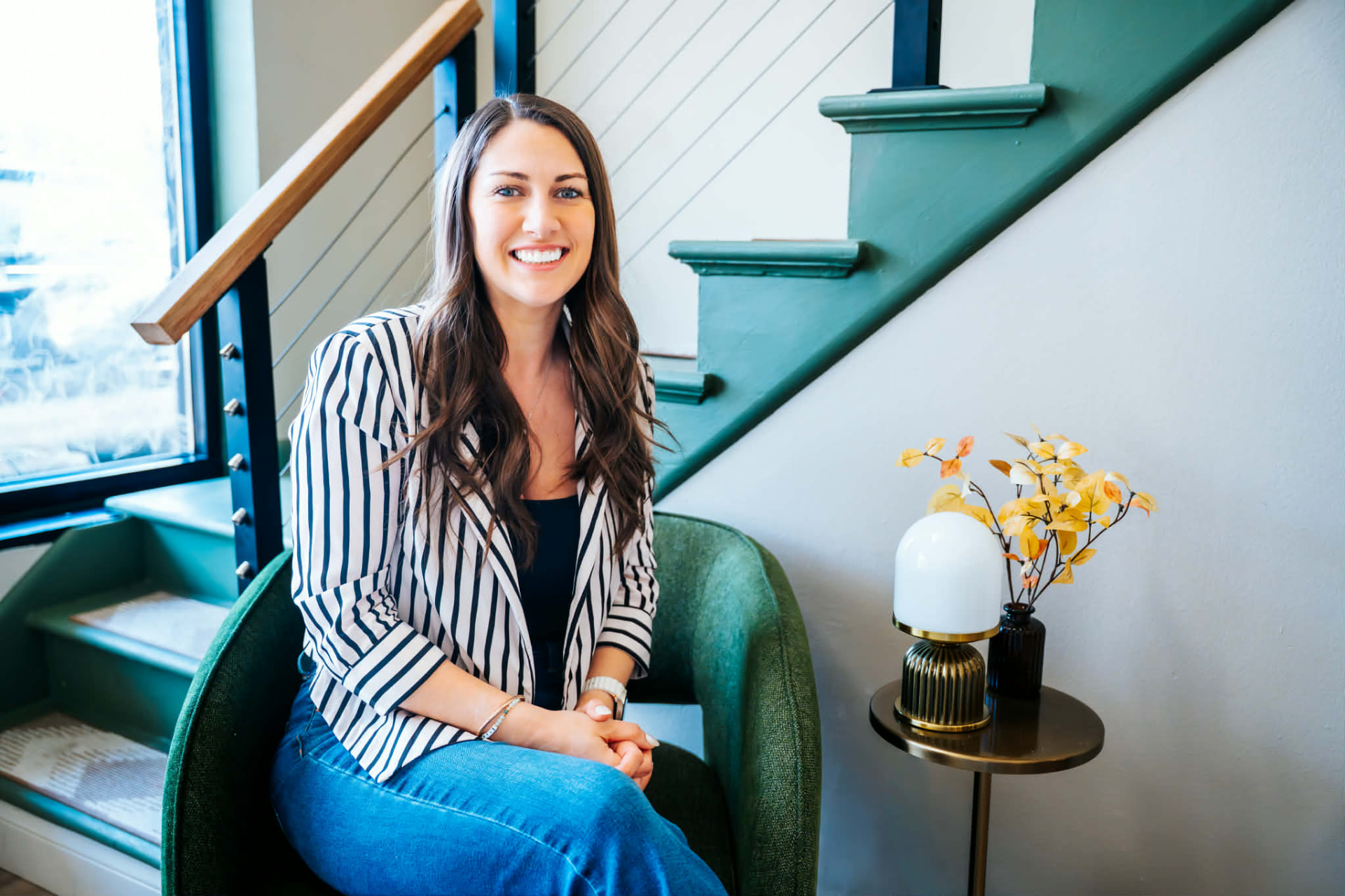 Danielle Strickler smiling in a bright staircase lounge